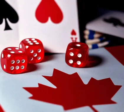 Three red dice and playing cards on a background featuring the Canadian flag